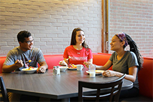 Three people sitting in a dining booth