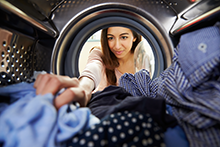 Person retrieving laundry from a dryer