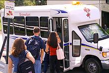 Students getting onto a shuttle bus